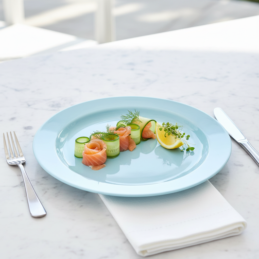 Assiette ronde bleu ciel 24 cm avec saumon fumé concombre et aneth sur marbre blanc, brunch estival élégant